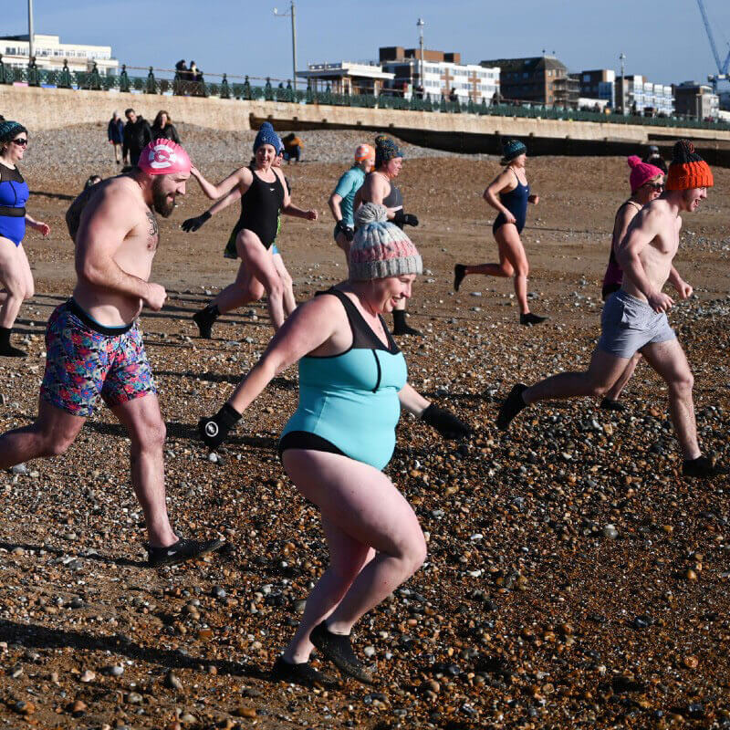 numerous people in bathing costumes running towards the sea from big boys don't cry documentary